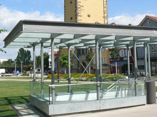 Park with shrubs, lawn and staircase leading to the underground garage